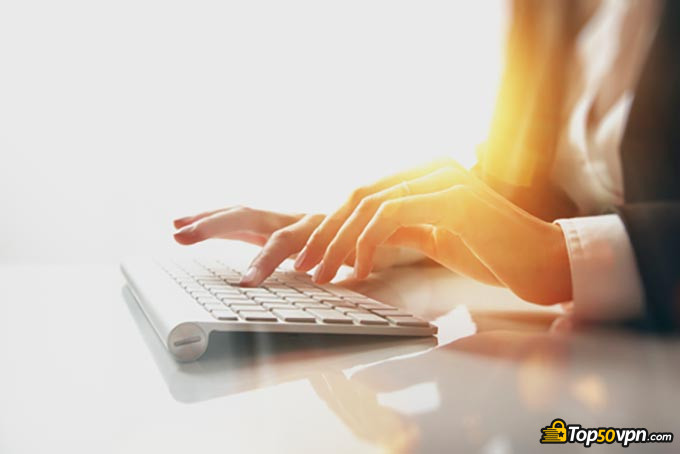 Diferentes tipos de VPNs: uma mulher digitando algo em um teclado.