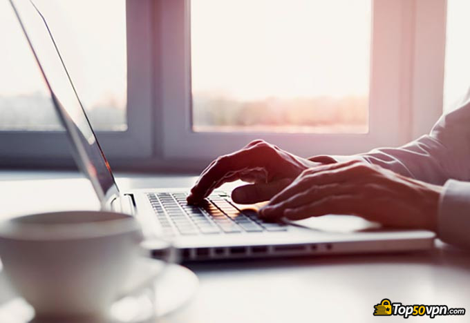 Diferentes tipos de VPNs: um homem escrevendo e bebendo café.